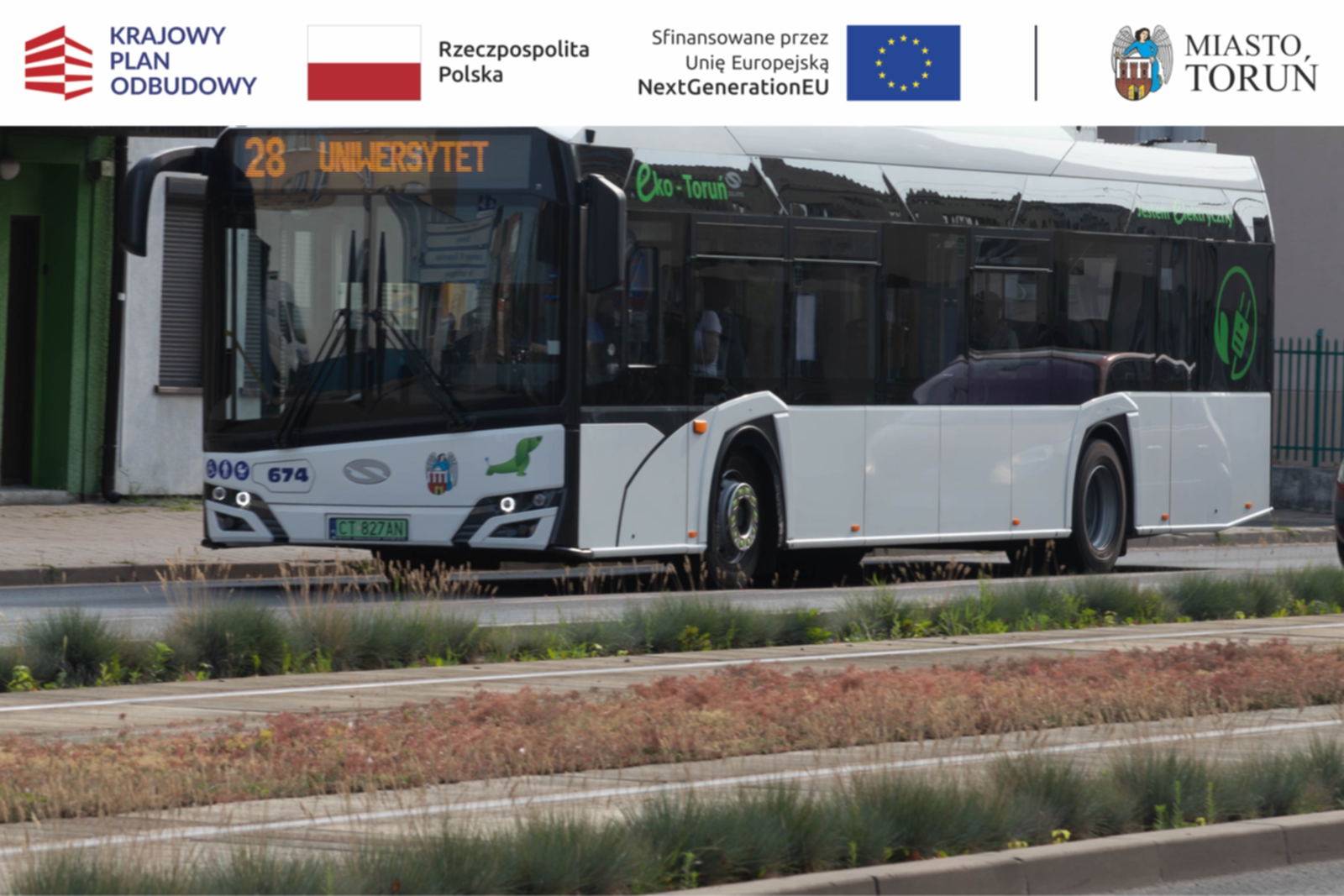 miejski autobus elektryczny koloru białego jadacy po jezdni wzdłuż torowiska tramwajowego
