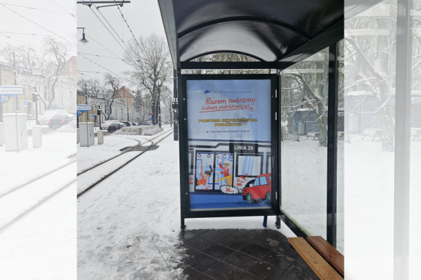 Zdjęcie wiaty przystankowej z grafiką nt. trzymania się poręczy w komunikacji miejskiej